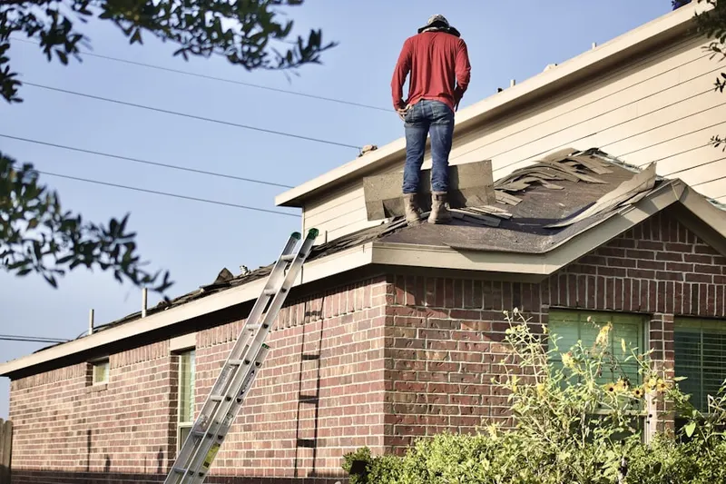 Professional roofer working on a residential roof in Belspur